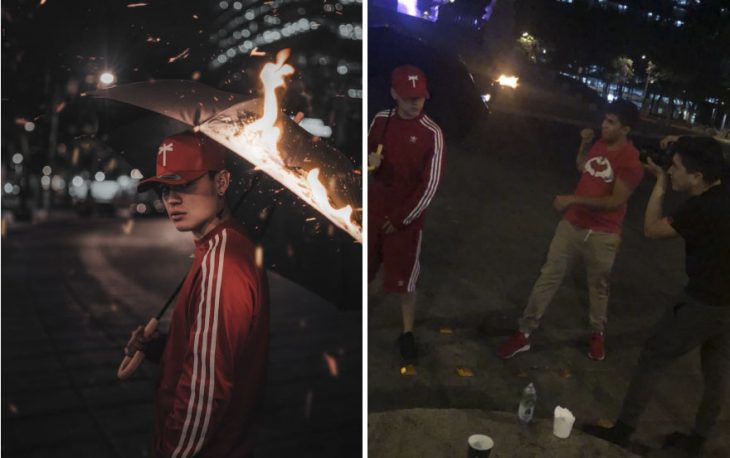 Chico con pants rojo y franjas blancas, sosteniendo un paraguas bajo una lluvia falsa, fotografía creativa de Omahi