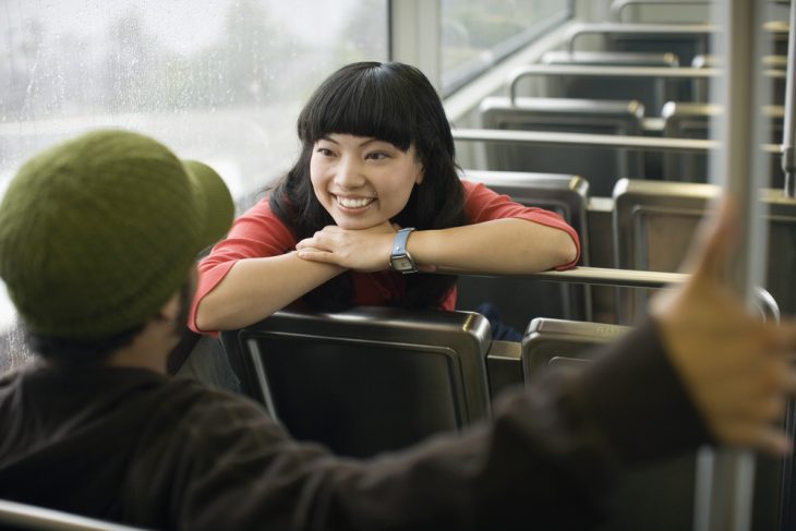 Mujer platicando con un desconocido en el transporte publico 