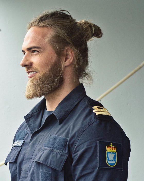 Lasse Lokken Matberg, modelo, hombre uniformado de cabello rubio y largo, con barba y bigote