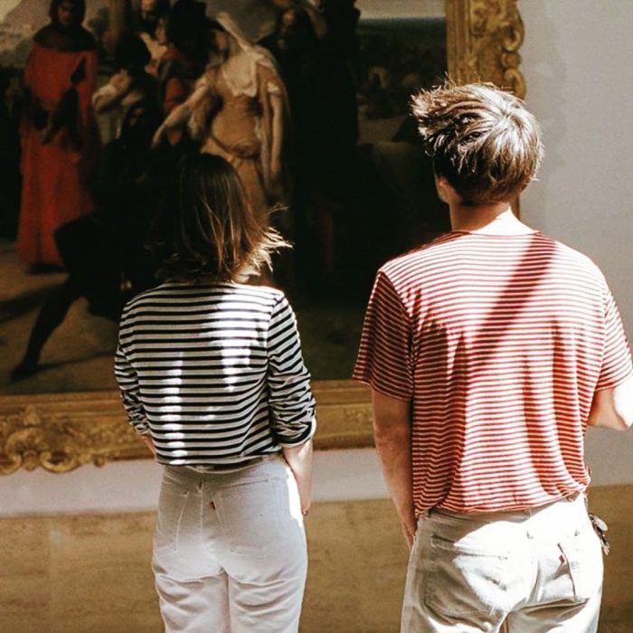 Una pareja de jóvenes disfrutando de una obra de arte en un museo 