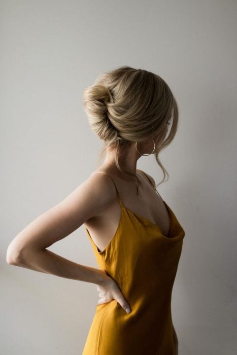 Girl modeling a yellow dress with a French twist hairstyle