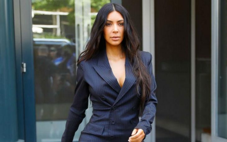 Chica con cabello XXL usando traje sastre negro mientras camina por la calle, Kim Kardashian quiere ser abogada