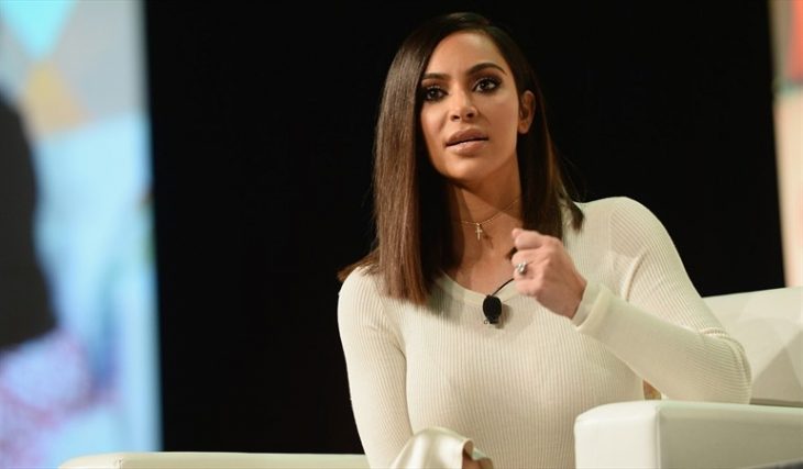 Chica sentada en un sofa blanco dando un discurso en medio de un foro, Kim Kardashian quiere ser abogada