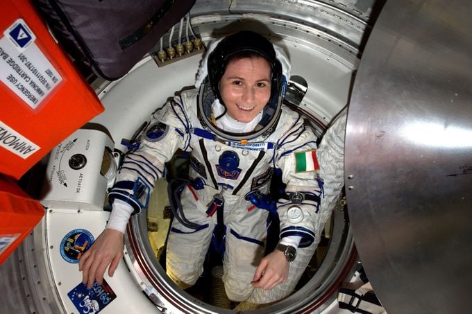 Mujer vestida de astronauta dentro de una nave espacial de la NASA, Anne McClain