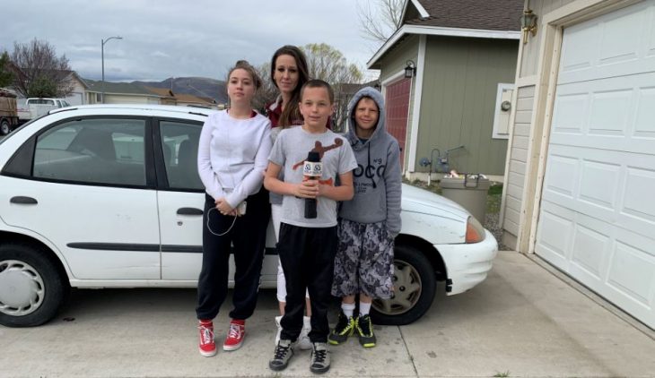 Hijo le regala un auto Toyota blanco a su mamá, familia posa en la calle frente al carro