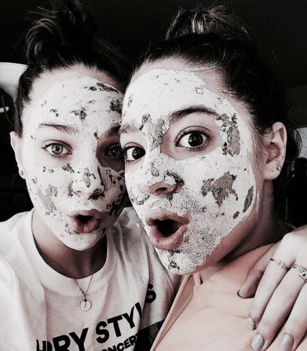 Chicas usando mascarilla facial para eliminar impurezas mientras toman selfies 