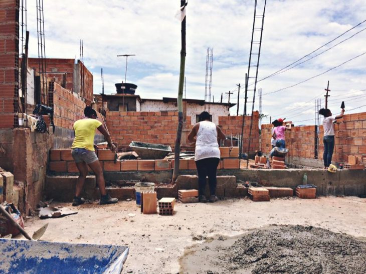 Mujeres brasileñas aprenden técnicas de arquitectura para construir sus propias casas, grupo de mujeres poniendo ladrillos