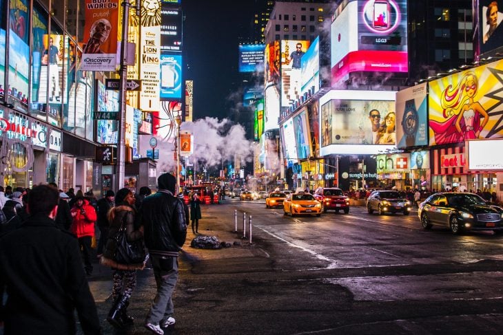 New York City full of people, in the middle of the night, with business lights on