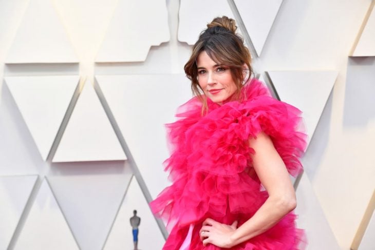 Peinados y looks que los Óscar 2019, Linda Cardellini con caberro recogido en chongo alto y despeinado, vestido rosa amplio de tul esponjado