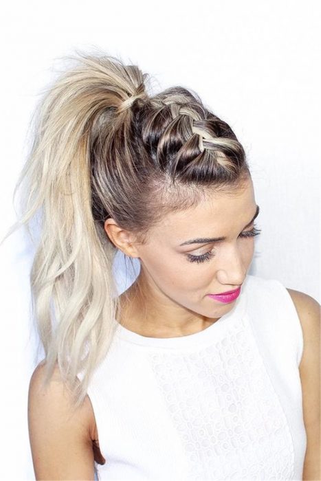 Chica con top blanco, peinada con una coleta de trenzas