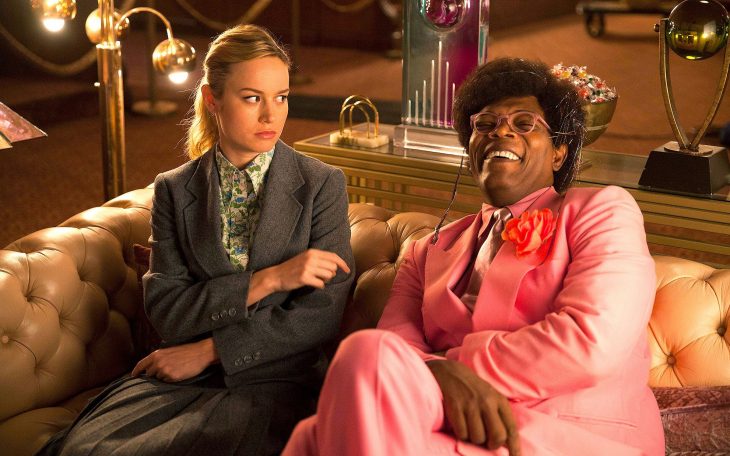 Scene from the Netflix movie Unicorn Store featuring Samuel L. Jackson and Brie Larson sitting on a couch laughing 