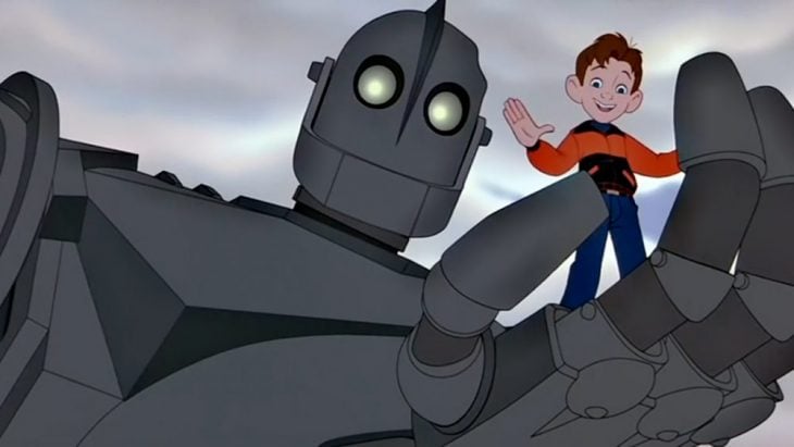 Dibujo animado de un robot de hierro sujetando a un niño en la palma de su mano, escena de la película El gigante de hierro 