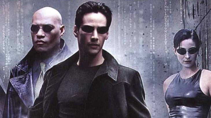 Grupo de personas usando gafas y ropa oscuras, bajo la lluvia, escena de la película Matrix, Keanu Reeves, Carrie-Anne Moss, Laurence Fishburne