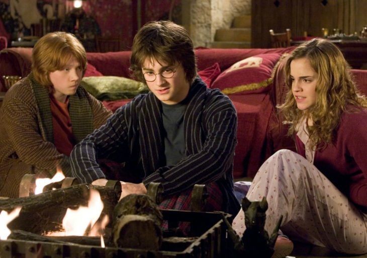 Ron, Harry y Hermione sentados en la sala común de Gryffindor en la película Harry Potter y el cáliz de fuego