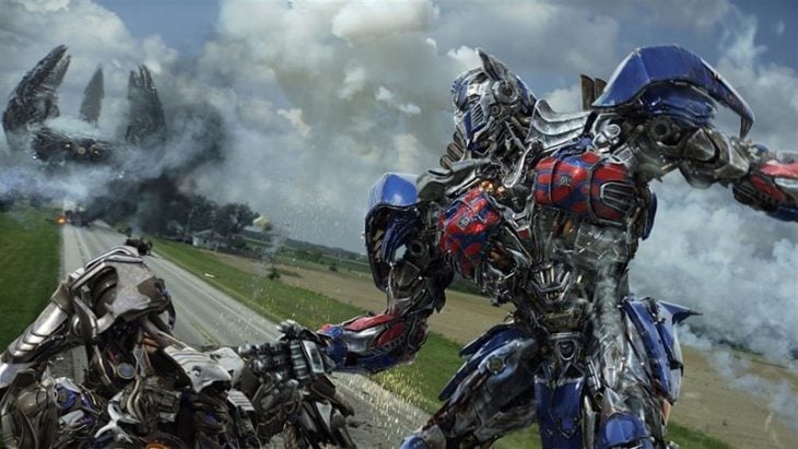 Robot metálico levantando a otro robo escena de la película Transformers: la era de la extinción 