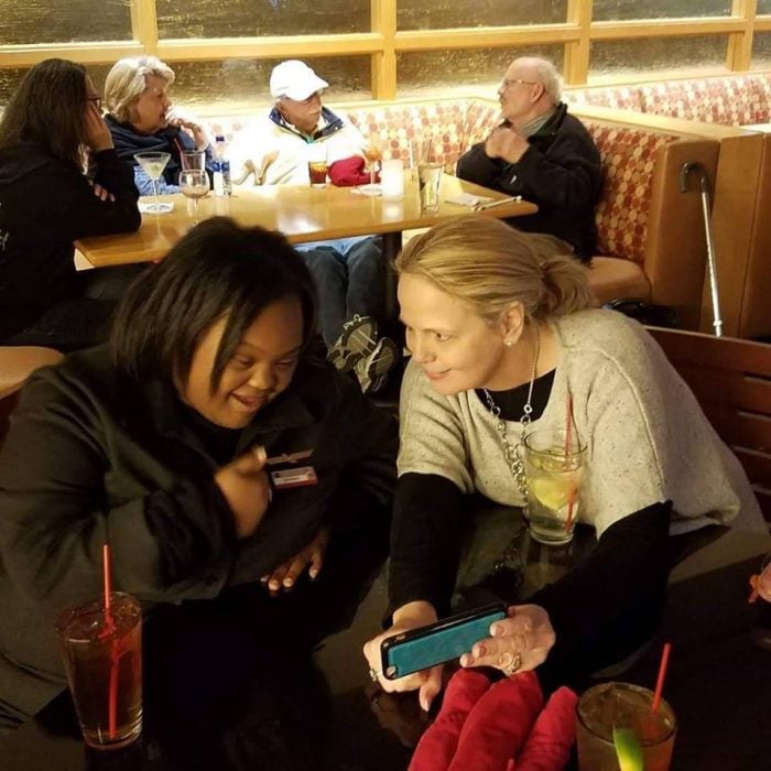 Shantell Pooser , mujeres en una sala de espera en un comedor de aeropuesto, mirando la tablet, antes de volar en American Airlines