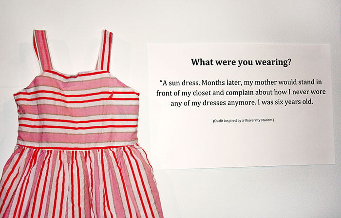 Cartelón que muestra el vestido que usó una victima de abuso cuando era una niña