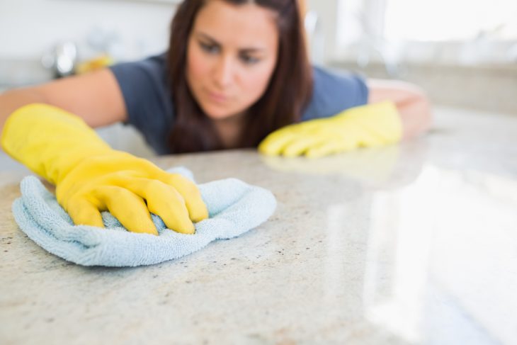 Chica con limpiando la mesa de la cocina