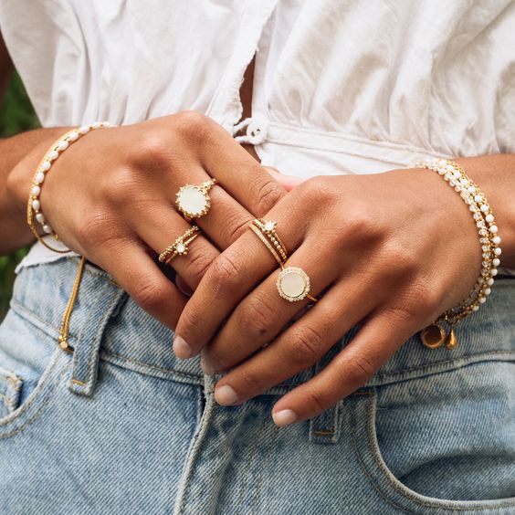Manos de mujer con anillos y pulseras doradas