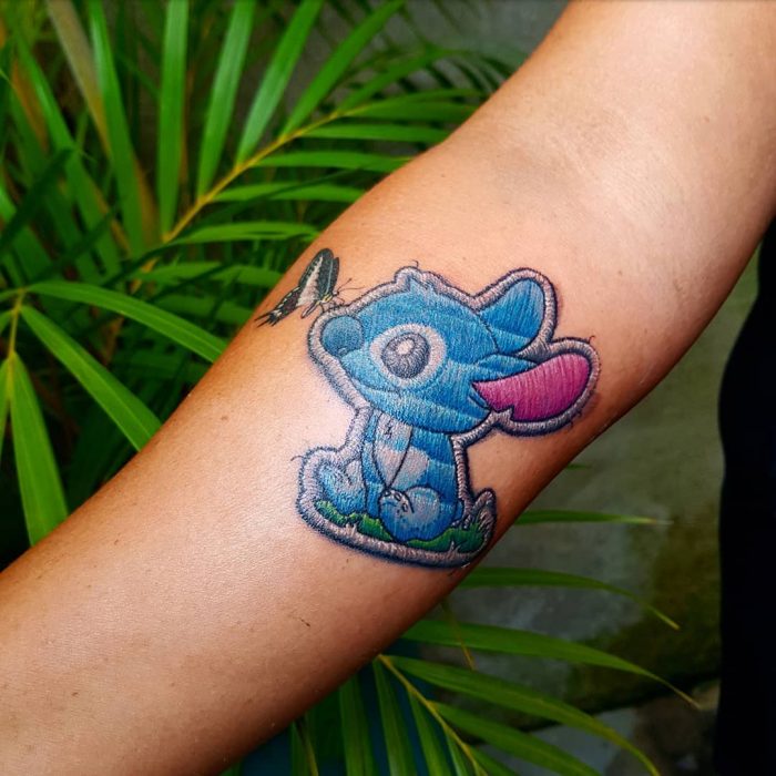 Tatuaje de Lilo y Stitch bordado en el brazo, de tatuador brasileño Eduardo "Duda" Lozano