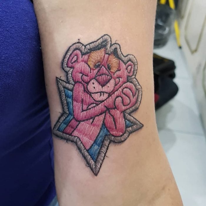Tatuaje bordado de la Pantera Rosa en el brazo, de tatuador brasileño Eduardo "Duda" Lozano