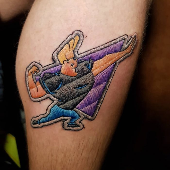 Tatuaje bordado de johnny Bravo en la pierna, de tatuador brasileño Eduardo "Duda" Lozano