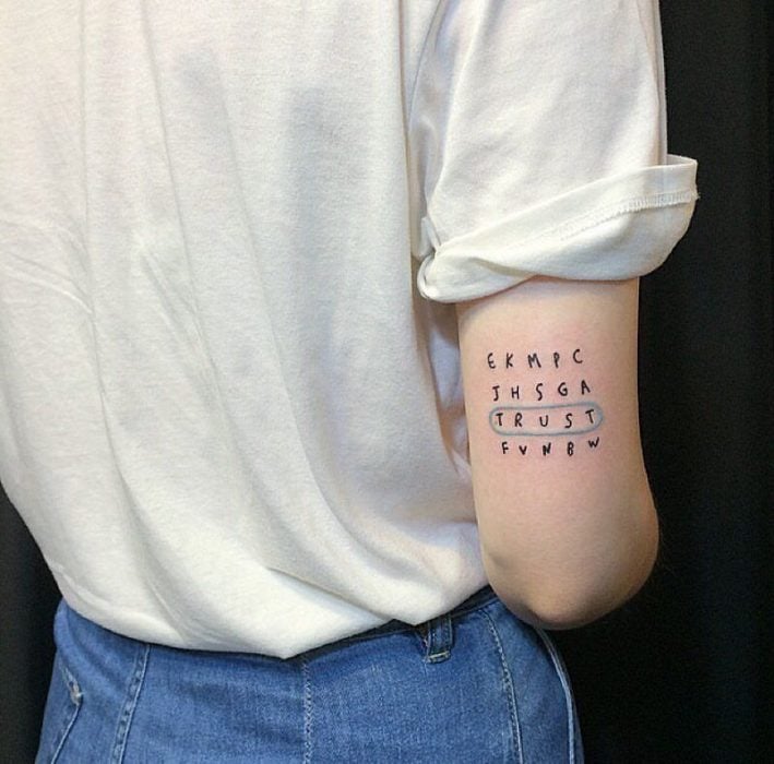 Tatuaje pequeño de una sopa de letras en el antebrazo
