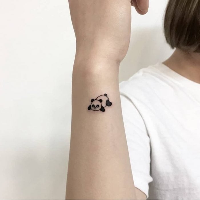 Tatuaje pequeño de un panda en la muñeca