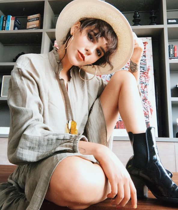 Blogger Yuya, brown-haired girl with fringe, wearing a bone-colored hat, black boots and big gray dress, oversized trend