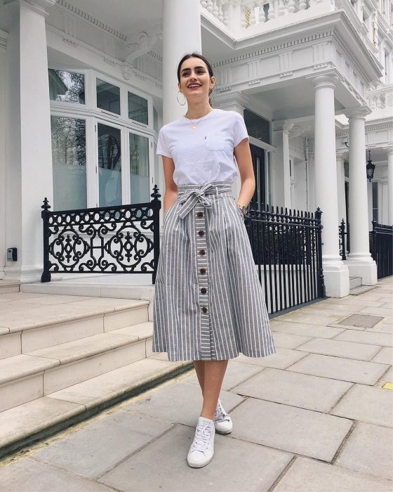 Chica modelando una falda con volumen, una camiseta blanca y tenis blancos