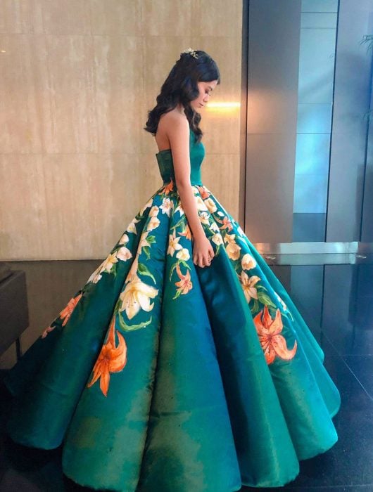Estidiante filipina Ciara Gan confeccionó su propio vestido de graduación ampón largo, verde esmeralda, con flores de tigre anaranjadas