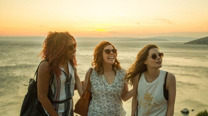 Tres chicas disfrutando de la conversación en la playa