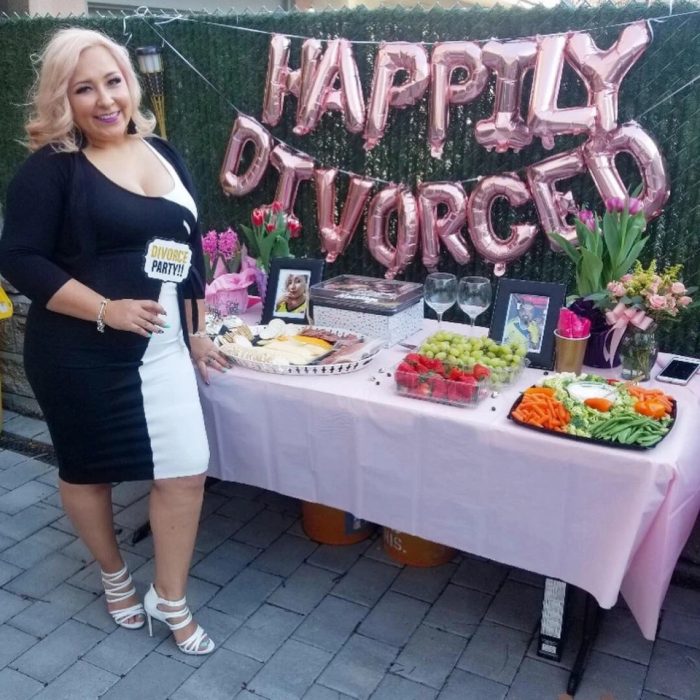 Mujer parada junto a una mesa de postres mientras festeja su feliz fiesta de divorcio 