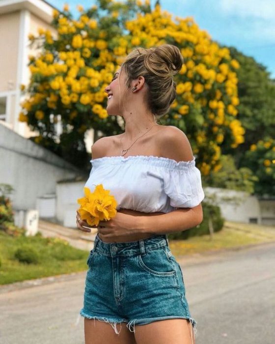 Mujer con flores amarillas en las manos