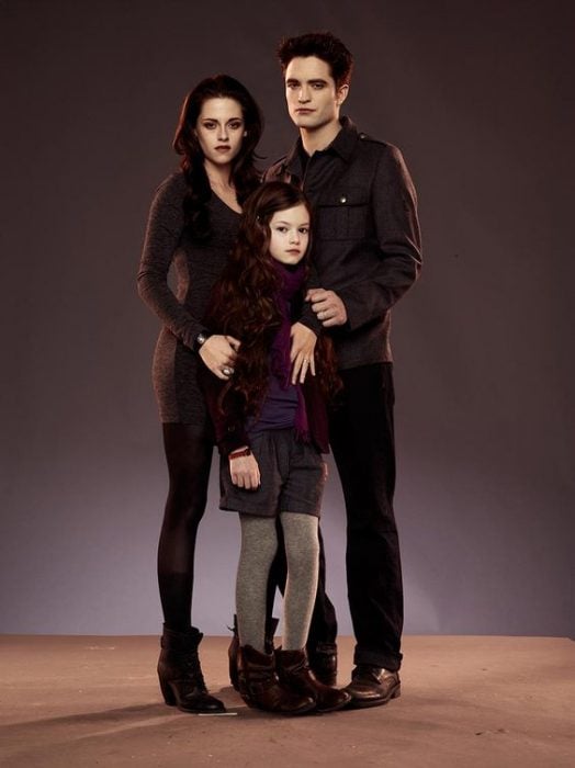 Bella Swan and Edward Cullen with their daughter Renesme posing before the camera
