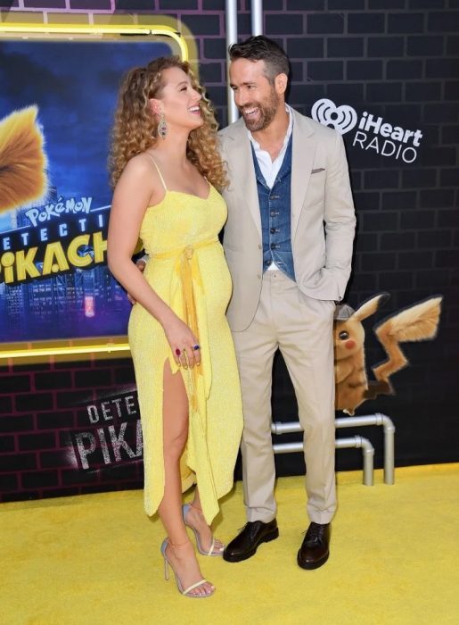 Blake Lively y Ryan Reynolds abrazados, posando para una foto durante la alfombra amarilla del estreno de Detective Pikachu