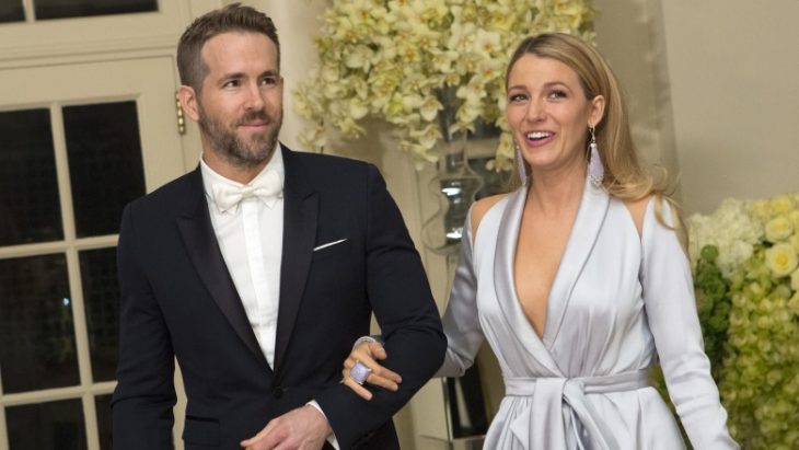 Blake Lively y Ryan Reynolds tomados de la mano, llevando ropa elegante mientras caminan por una alfombra roja