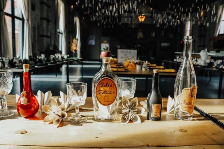 Novios se casan en boda inspirada en Harry Potter; mesa con copas, flores de papel y pócima Felix Felicis