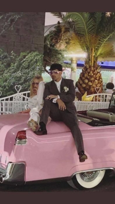 Joe Jonas y Sophie Turner después de su boda en las Vegas sentados en un automóvil de color rosa posando para una foto 