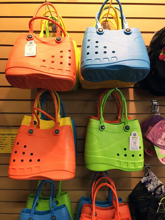 Bolsas inspiradas en las sandalias Crocs de diferentes colores colgadas en un estante 