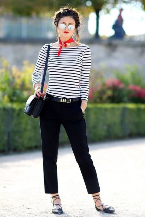 Chica con cabello recogido con trenza, blusa estilo nay y pantalón azul marino en la calle