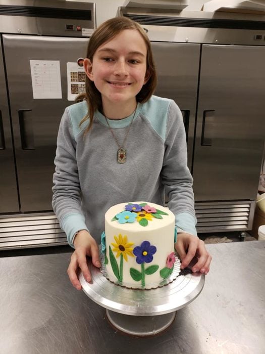 Emily Athey mostrando su pastel ya decorado 