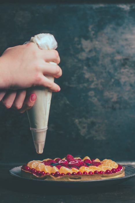 manos de mujer decorando una tarta