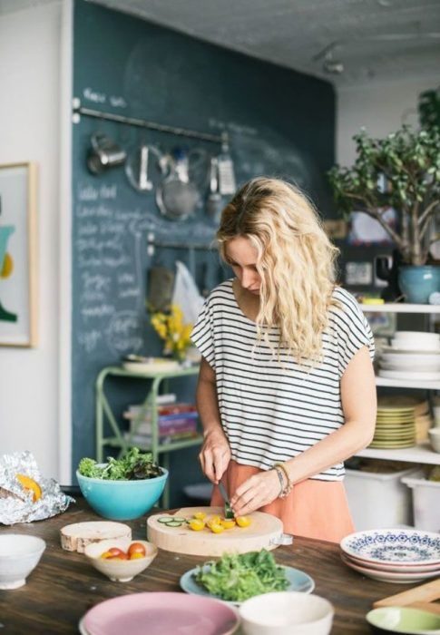 Mujer rubia en cocina preparando alimentos sanos