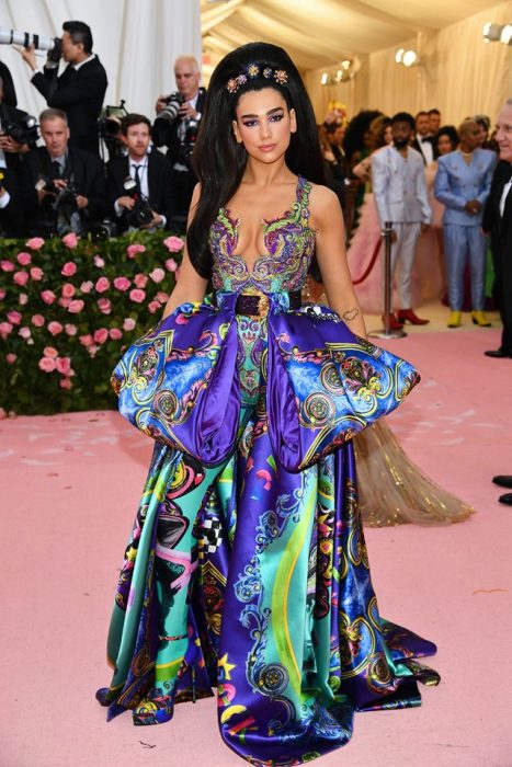 Dua Lipa usando un vestido de color azul con estampados verdes y morados durante la Gala MET de Nueva York