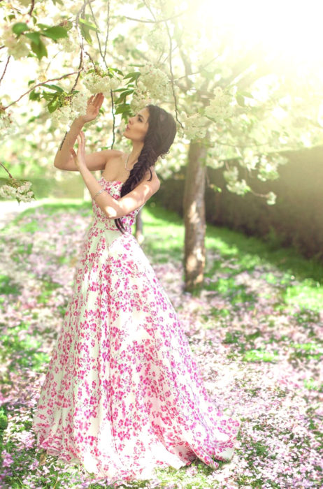 Ideas para fiesta de XV años con temática japonesa; vestido largo en forma A sin hombros y escote de corazón, con estampado de flores de cerezo, peinado de trenza ancha al lado