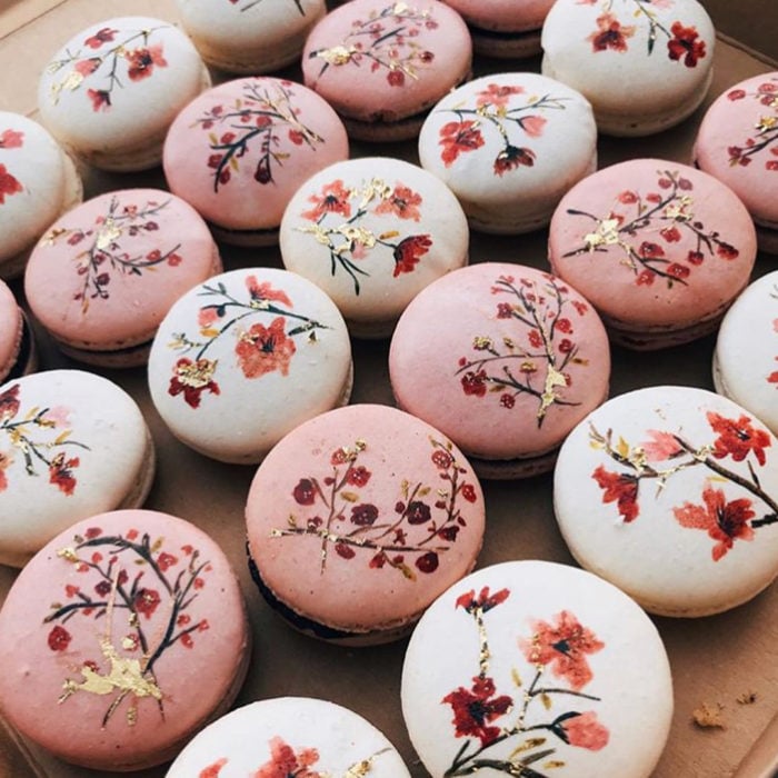Ideas para fiesta de XV años con temática japonesa; macarrones franceses de color blanco y rosa con dibujo de flores de cerezo