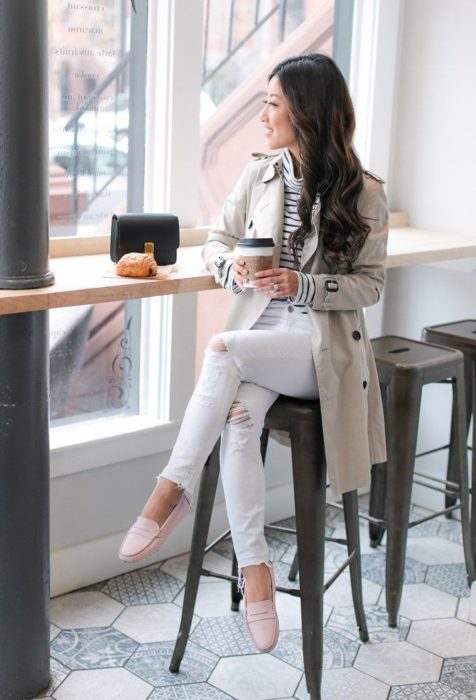 Chica sentada en un restaurante tomando un vaso de café 