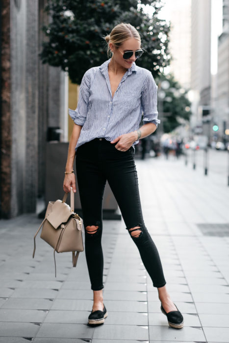 Chica parada en medio de la calle mostrando sus zapatos flats estilo alpargatas de tacón bajo 