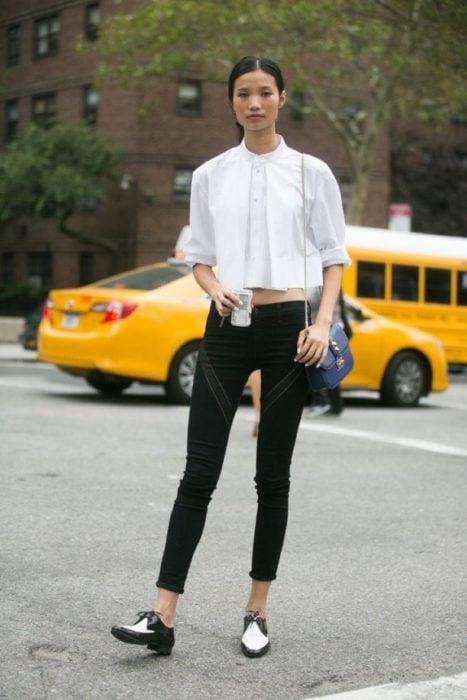 Chica parada en la calle luciendo su outfit y sus zapatos de color blanco con negro estilo mocasines 